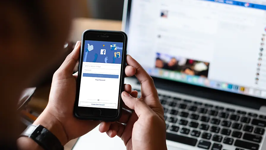 Facebook aberto em notebook e celular durante a gestão de campanhas de Facebook Ads